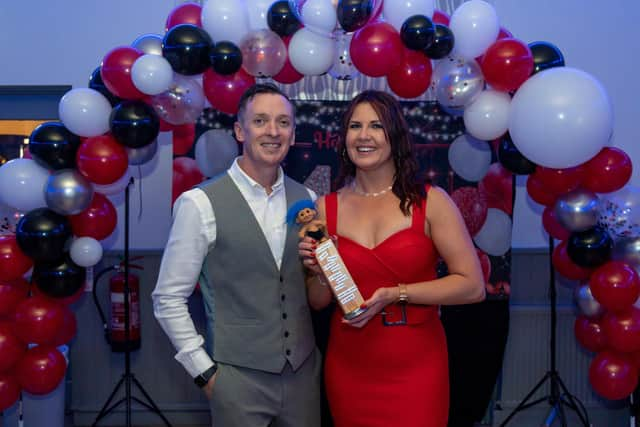 Leanne Conroy with husband Andy Conroy holding a replica of 'The Geller Cup' (from the TV series 'Friends') which she received as birthday gift. Picture: Mike Cooter (150423)