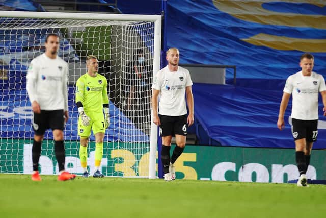 Portsmouth's Jack Whatmough and Portsmouth's Craig MacGillivray look dejected after Brighton and Hove Albion defender Bernardo Fernandes da Silva Junior scores his first goal of the match