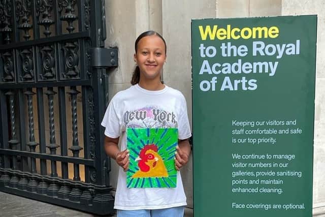 Isabella holds her painting. 