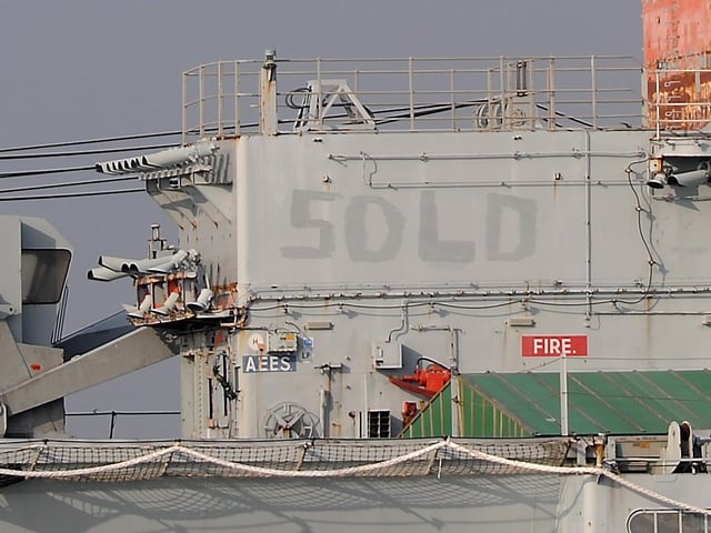 The word 'sold' can be seen on the side of Invincible.Hundreds of people watched aircraft carrier HMS Invincible make her final journey this morning Thursday, as she was towed out of Portsmouth dockyard in the sunshine. The aircraft carrier, which famously served in the Falklands War, was towed out of Portsmouth Harbour at 8am. She is heading to a Turkish scrapyard to be broken up and recycled. Large numbers turned out at the Round Tower in Old Portsmouth to say a final farewell to the ship, including members of The Invincible WO’s & CPO’s 82 Association. Picture: Chris Balcombe