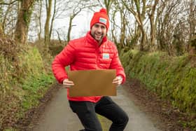 Matt Johnson, People’s Postcode Lottery ambassador, holding a golden envelope while jumping - or possibly doing a bizarre form of squat - as eight lucky Emsworth residents bagged £1,000 each this week. Photo: Adam Davies.
