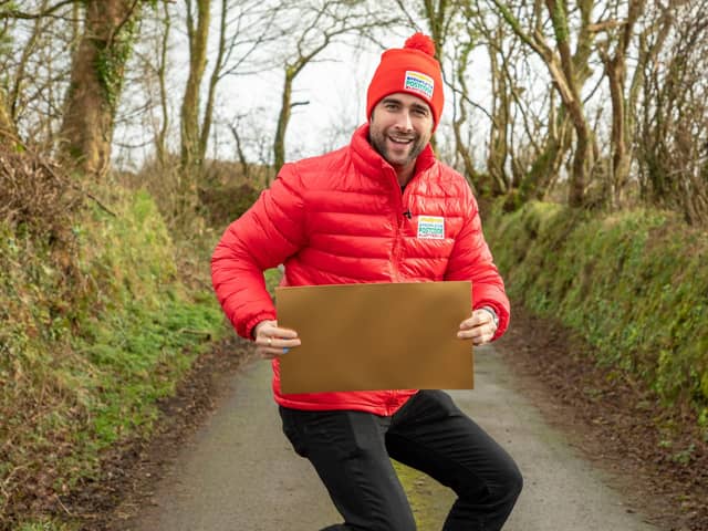 Matt Johnson, People’s Postcode Lottery ambassador, holding a golden envelope while jumping - or possibly doing a bizarre form of squat - as eight lucky Emsworth residents bagged £1,000 each this week. Photo: Adam Davies.