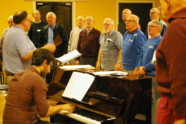 Choir members rehearse.
