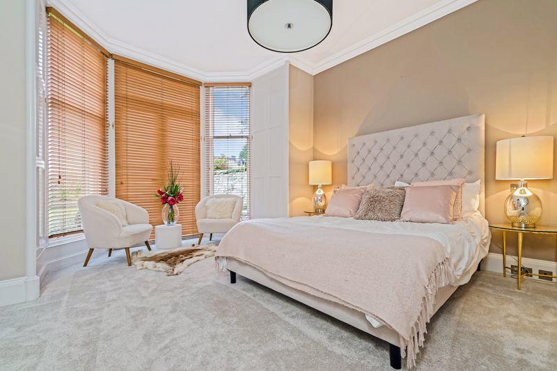 The master bedroom suite on the ground floor is fitted with luxury Saxony carpets, has a large bay window with double door access to the rear garden, and features a dressing room with fitted wardrobes.