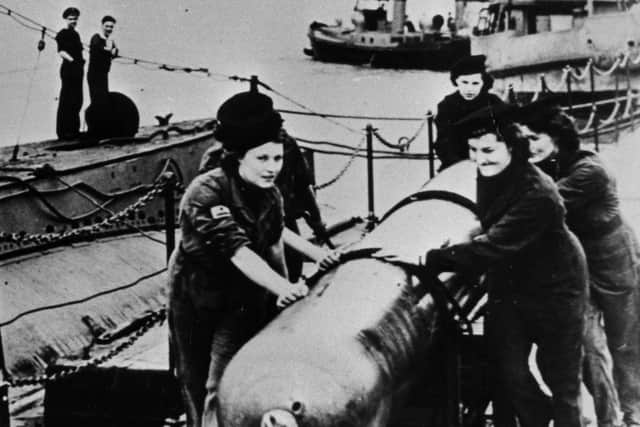 Wrens loading a torpedo on to a submarine at HMS Dolphin, Gosport, during the Second World War. The News PP5376