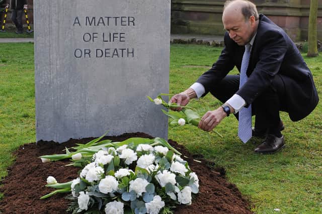 Climatologist Dr James Hansen, and Director of NASA's Goddard Institute for Space Studies, poses for pictures beside a mock grave reading "Climate Change, a Matter Of Life Or Death" (CARL DE SOUZA/AFP via Getty Images)