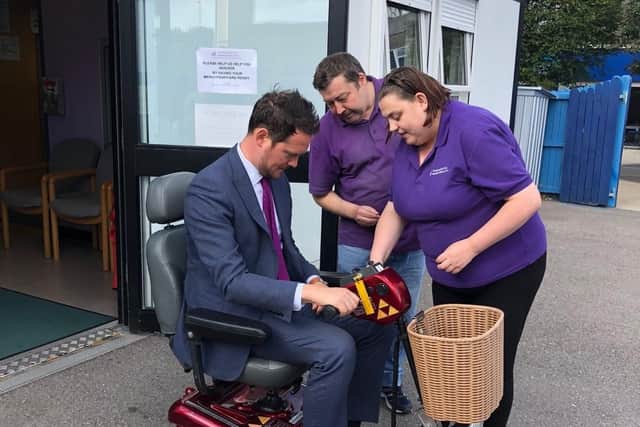 Shopmobility scheme volunteers Amy and Dave show MP for Portsmouth South Stephen Morgan how to use a scooter