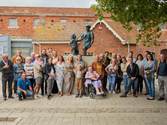Alexander Baldacchino in front of the Mudlarks' Memorial, centre, surrounded by his family and friends. Picture: Polly Richards