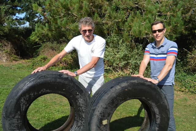 Cllr Kevin Casey, left, with local resident Brian Briggs and the tyres found in Stokes Bay. Picture: David George