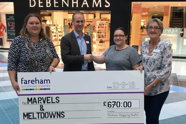 Fareham Shopping Centre manager Mike Taylor donates the cheque to Marvels and Meltdowns