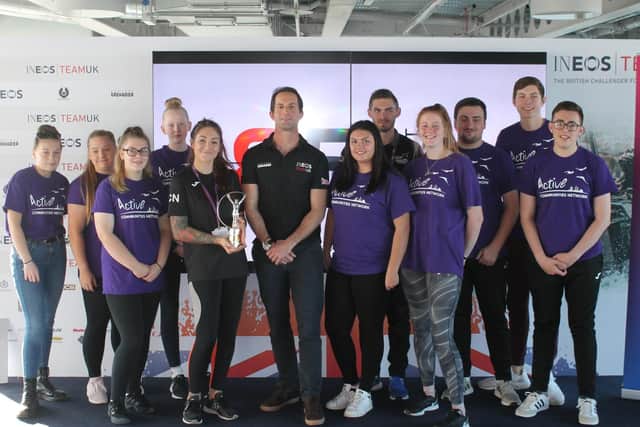 Sir Ben Ainslie (centre) with ACN staff Aysha Coker (with trophy) and Matt Luke (in black) alongside young people participating in the ACN support programme.