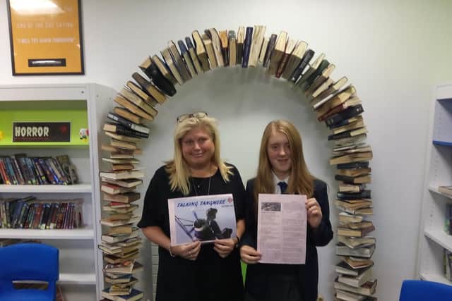 Olivia Milham, 13, holds a photocopy of her poem alongside head of English Sarah Gronow.