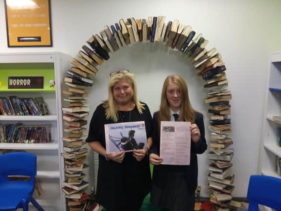 Olivia Milham, 13, holds a photocopy of her poem alongside head of English Sarah Gronow.