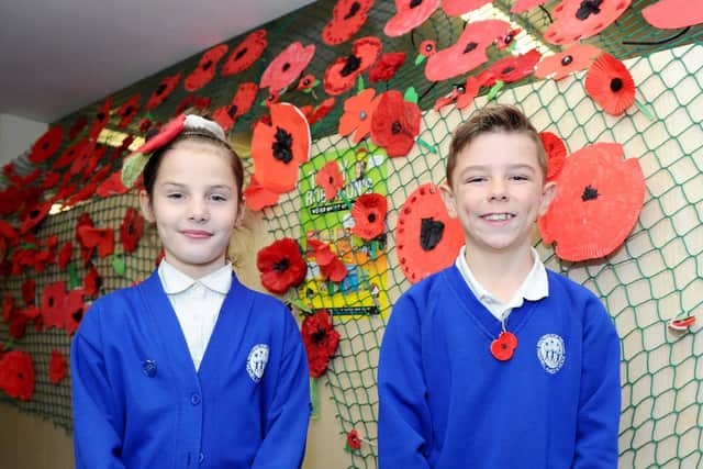 Cerys McIntosh (8) and Oliver Sutton (8) in the 'Poppy Corridor' alongside their work.