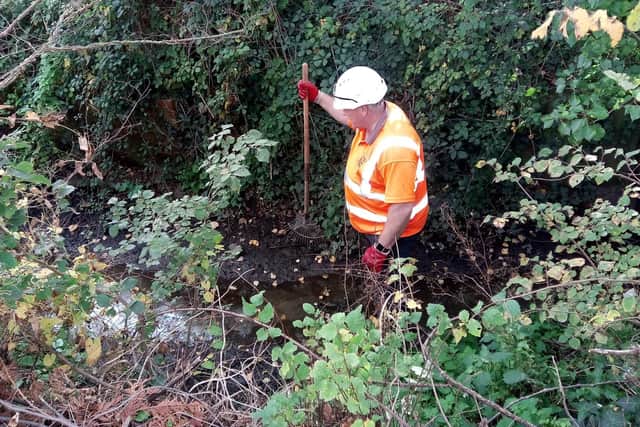 Southern Water workman removing debris from the drainage ditch.