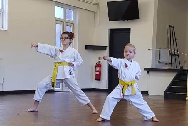 Youngsters Kara Cook, left, and Jazmyne Mcclelland show off their skills as they graded from yellow belt to orange belt.
