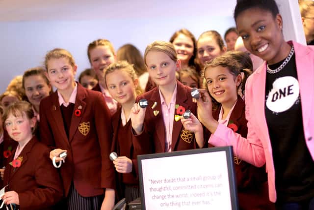 From left, Genevieve Newman, 10, Imogen Wallace, 10, Jemima Holden, 13, Isabelle Gabriel, 10, Erin Liu, 10, and Temilola Adeleye (One Campaign) display One Campaign badges in support of the fight against poverty
