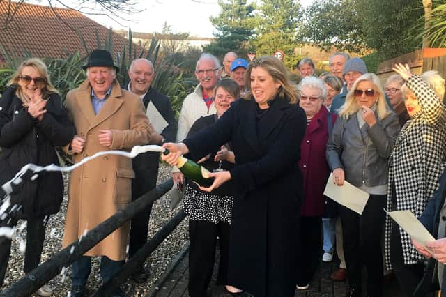 Penny Mordaunt, Portsmouth North MP, cracks open a bottle of champagne as Port Solent residents celebrate finally having sound barriers installed along the M27 to block out the deafening roar of the highway.