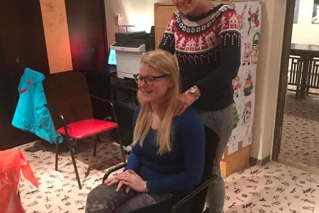 Helen Richards massages a fellow passenger while waiting for their flight back to the UK