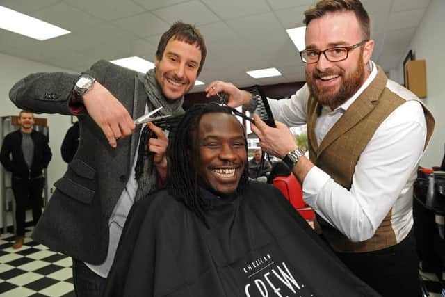 Razor Sharp barbers owners Matthew Staker, left, and Dominico Valente give Linvoy Primus a trim when they opened in 2015. Picture: Ian Hargreaves (150162-2)
