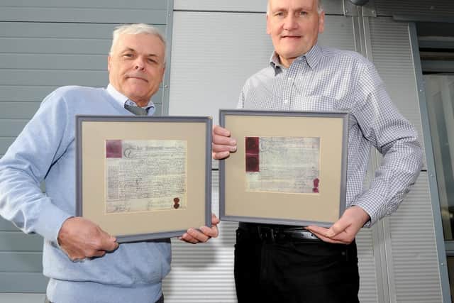(l-r) Co-directors of T Coleborn & Son Ltd Barry Thomas and Eric Coleborn, in Kirpal Road, Portsmouth. Pictured holding copies of the original apprenticeship indentures from 1783.Picture: Sarah Standing (150119-6119)