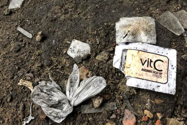 VitC sachet normally used when taking heroin pictured with a small plastic bag suspected of once containing drugs