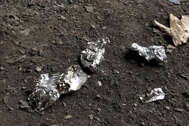 Dozens of small pieces of tinfoil were scattered in the den which source suspect were used in the preparation of heroin.