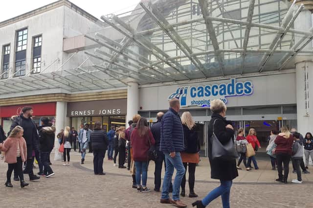 Shoppers waiting outside the Cascades Shopping Centre after being evacuated.