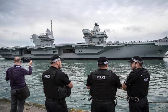 Armed police chat as HMS Queen Elizabeth sails into her home port of Portsmouth Naval Base on August 16, 2017. Picture: Carl Court/Getty Images