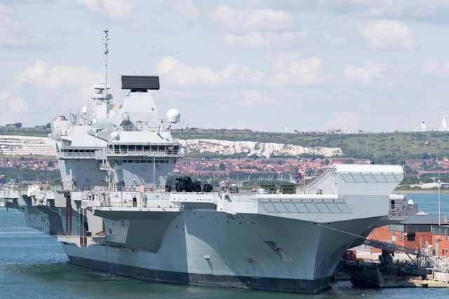 HMS Queen Elizabeth, pictured alongside at Portsmouth Naval Base. Photo by Matt Cardy/Getty Images