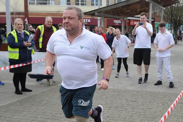 Antony Potts running with the pancake in the pan.