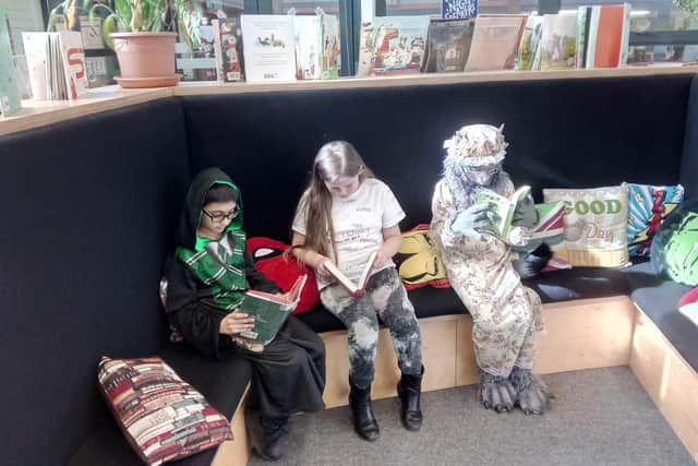 From left, Abdullah Khadir, 10, dressed as Harry Potter, Angel Marie, 9, dressed as a dictionary and Ellen Rollason, 10, dressed as the wolf from Little Red Riding Hood, reading in the Flying Bull Academy library Picture: Neil Fatkin