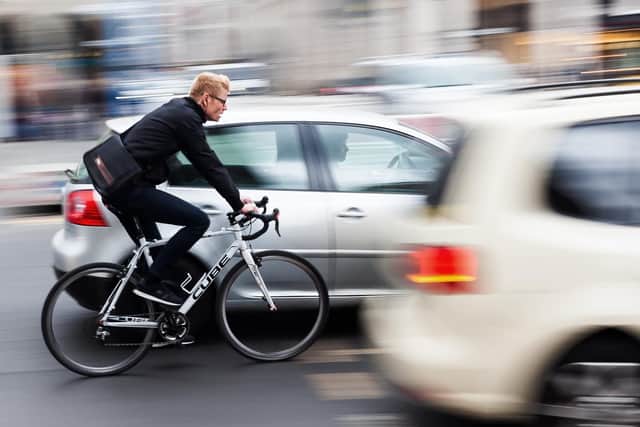 A cyclist not being given enough room by cars - but as motorists will point out, he's not wearing a helmet!