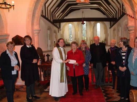 Rev Jenny Gaffin presenting the cheque to Sheila Proud of the Royal British Legion, with, from left, Dr Coleen Jackson, churchwarden and chair or the organising committee, Karen Cutting, Sue Palmer, Mike and Jill Burnham, Alysson Griffin and Carol Carter.