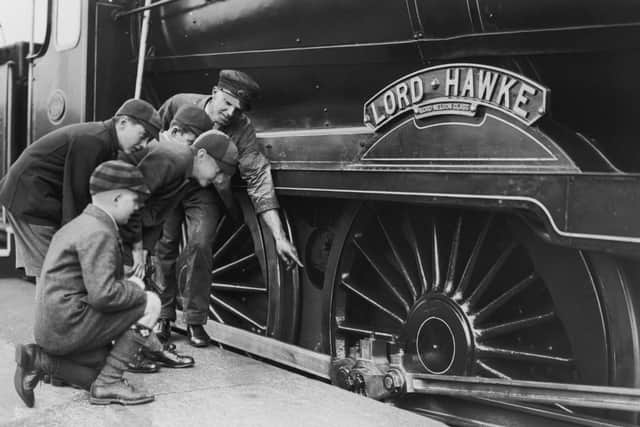 An engine driver showing a group of schoolboys over the Lord Nelson Class locomotive, Lord Hawke, during a train exhibition at Portsmouth Town Station, 21st October 1933. (Photo by J. A. Hampton/Topical Press Agency/Hulton Archive/Getty Images)