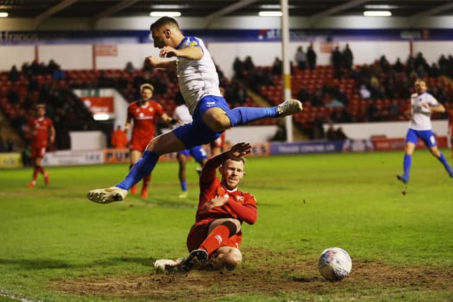 Lee Brown gets clear of a Walsall player as he reaches a new high