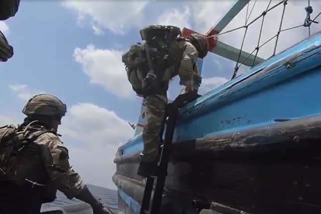 A Royal Marine clambers onto the fishing ship that was packed with 2,450kg of drugs. Photo: Royal Navy