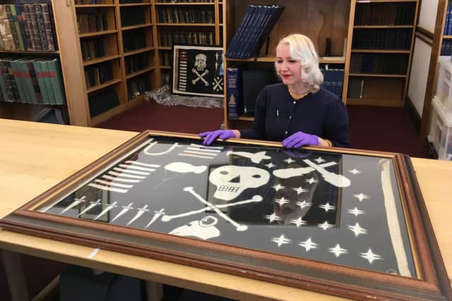 Curator Alice Roberts-Pratt with the HMS Torbay Jolly Roger