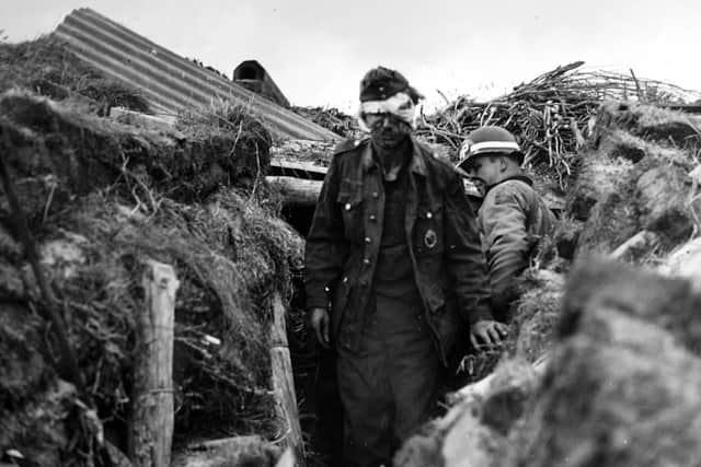 June 10, 1944 - Wounded Nazi Gunner Under Guard - Wounded and dazed, a German gunner is ushered out of his dugout by a watchful Army M.P. following the surrender somewhere along the French coast.