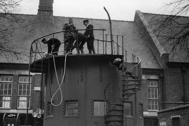 1933:  A man in diving gear prepares to undergo training at the diving school at Whale Island, Portsmouth. The specially designed tank is 16 feet deep and holds 160 tons of water. Divers learn how to manipulate tools under water.  (Photo by William Vanderson/Fox Photos/Getty Images)