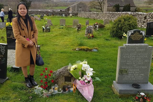 Buathong Trimble visits her cousin Lamduan Armitage's grave. Picture: Thai Women Network in the UK