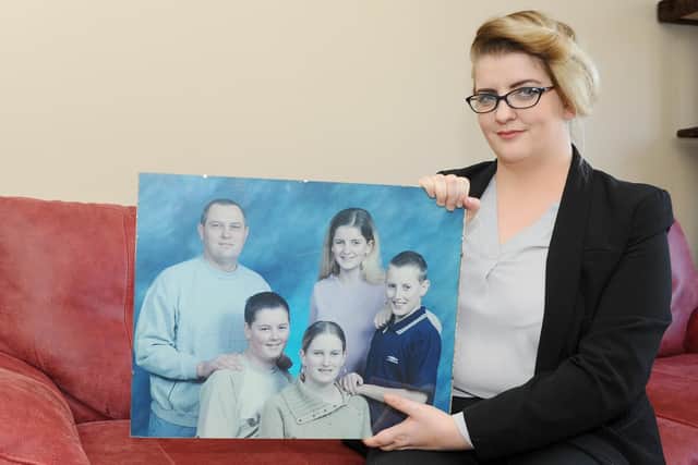 Kim Beecher holding a photograph they had taken in 2005 for her mum of her dad and siblings. Picture: Sarah Standing (290319-4639)
