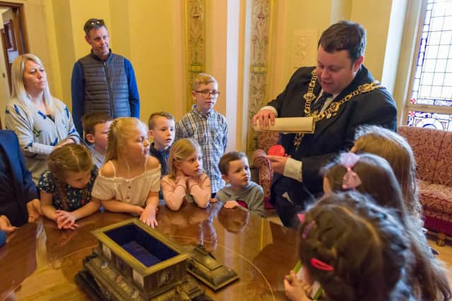 Children's group, Dream Catchers are holding their very own children's parliament at the Guildhall, Portsmouth - Cllr Lee Mason, Lord Mayor of Portsmouth shows the children a seal and scroll dating from 1901 giving the freedom of the city to Alderman Sir William Pink. Picture: Duncan Shepherd