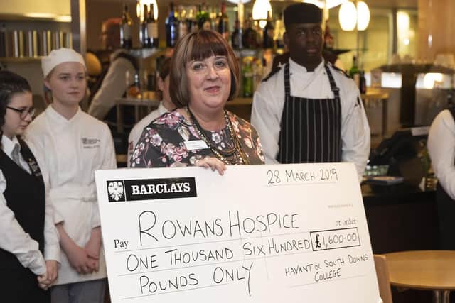 Rowans Hospice chief executive, Ruth White, is presented with a cheque as Royal Navy chefs and stewards team up with students at Havant and South Downs College to cook a special lunch for the charity. Picture: MoD/Crown Copyright. Picture: MoD/Crown Copyright