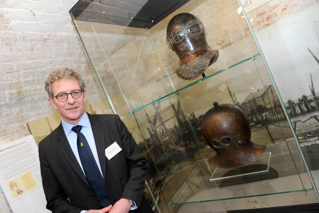 Museum director Kevin Casey next to the Deane Helmet (top) and the James helmet Picture: Sarah Standing (050419-5685)