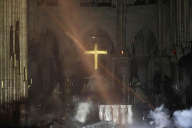 Smoke is seen around the alter inside Notre Dame cathedral following the devastating fire. Picture (Philippe Wojazer/Pool via AP)