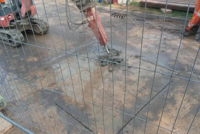 Engineers look to gain access to the burst sewage pipe.