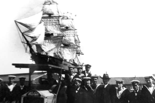 Sailors pose in front of a fully-rigged ship. I have no idea where this was taken or what it celebrates. Perhaps readers can enlighten me?