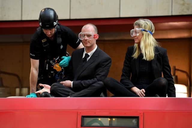 Police remove environmental campaigners from the top of a DLR train at Canary Wharf underground station. Picture: Leon Neal/Getty Images