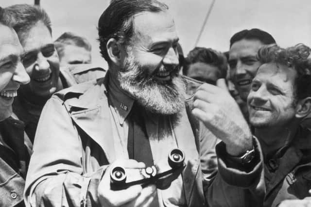 1944:  American writer Ernest Hemingway (1899 - 1961) travelling with US soldiers, in his capacity as war correspondent,  on their way to Normandy for the D-Day landings.  (Photo by Central Press/Getty Images)
